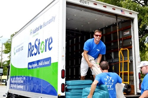 Habitat Spartanburg ReStore Manager Joe Walker unloads patio sets donated by the Carolina Panthers organization. 